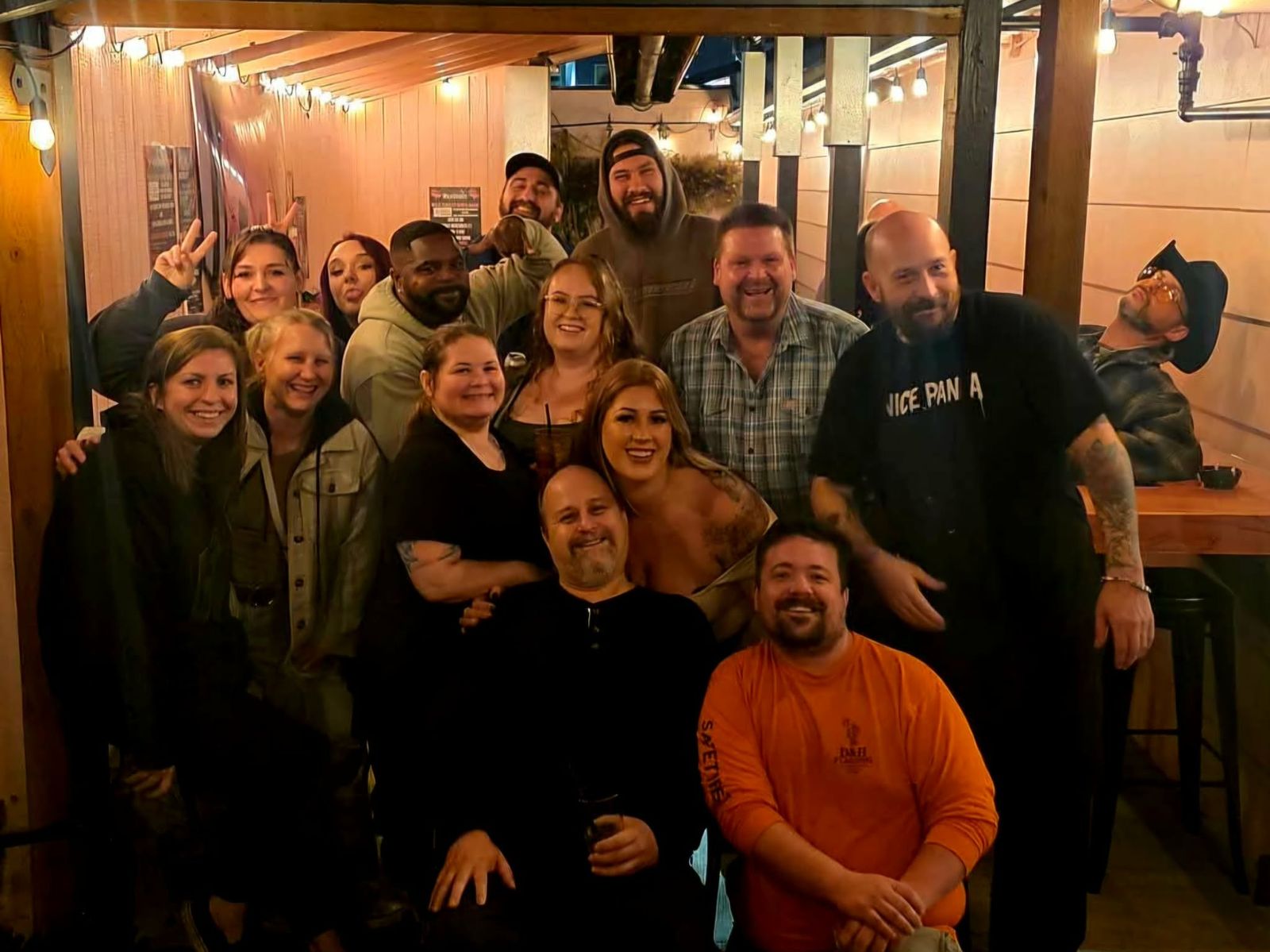 A big group together under the patio string lights