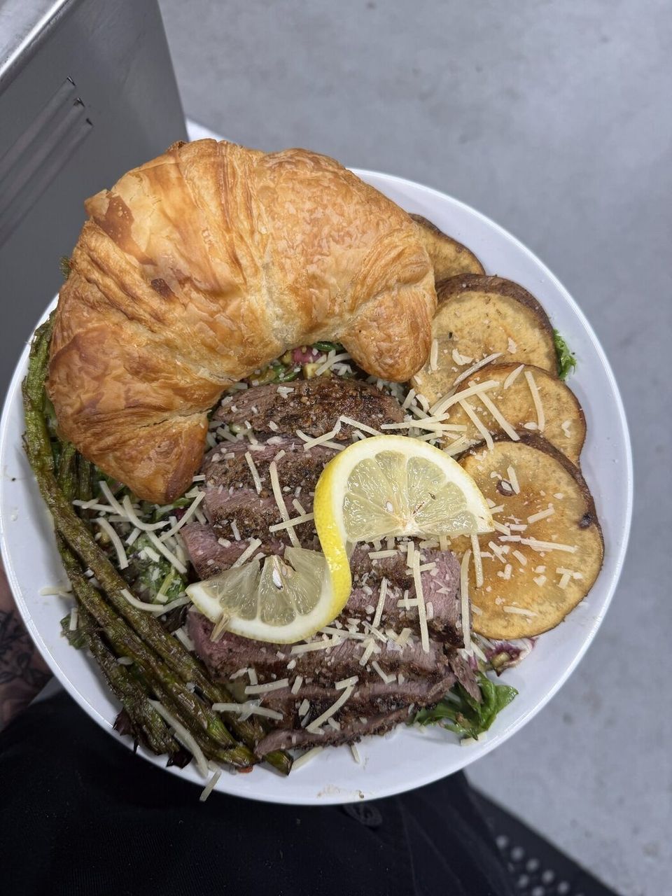 Croissant plate with shaved meat, asparagus and lemon