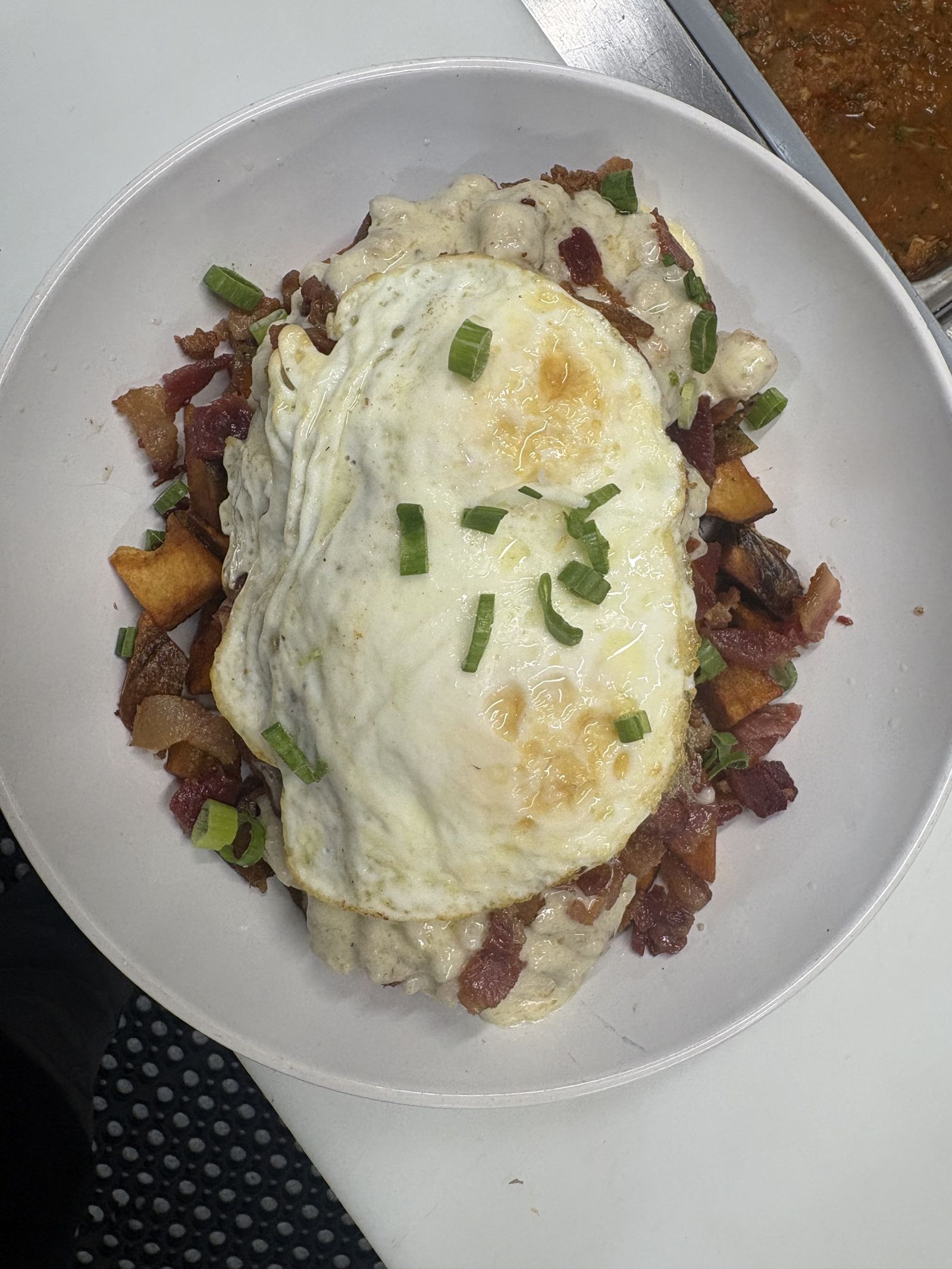 Fried egg over crispy potatoes and hash with green onion