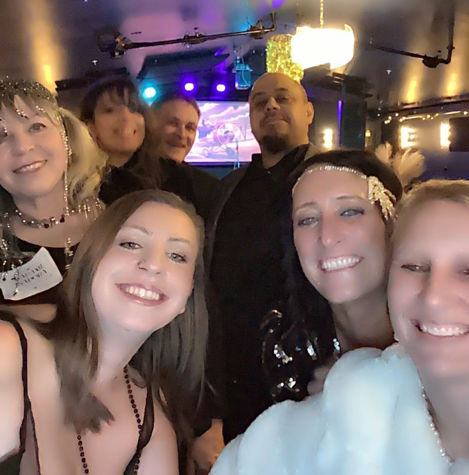 Group selfie in front of the stage at the murder mystery party