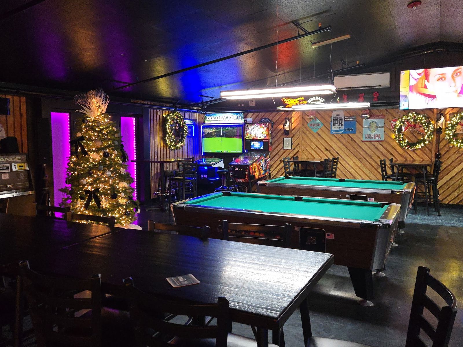 Pool tables under holiday lights in the back room