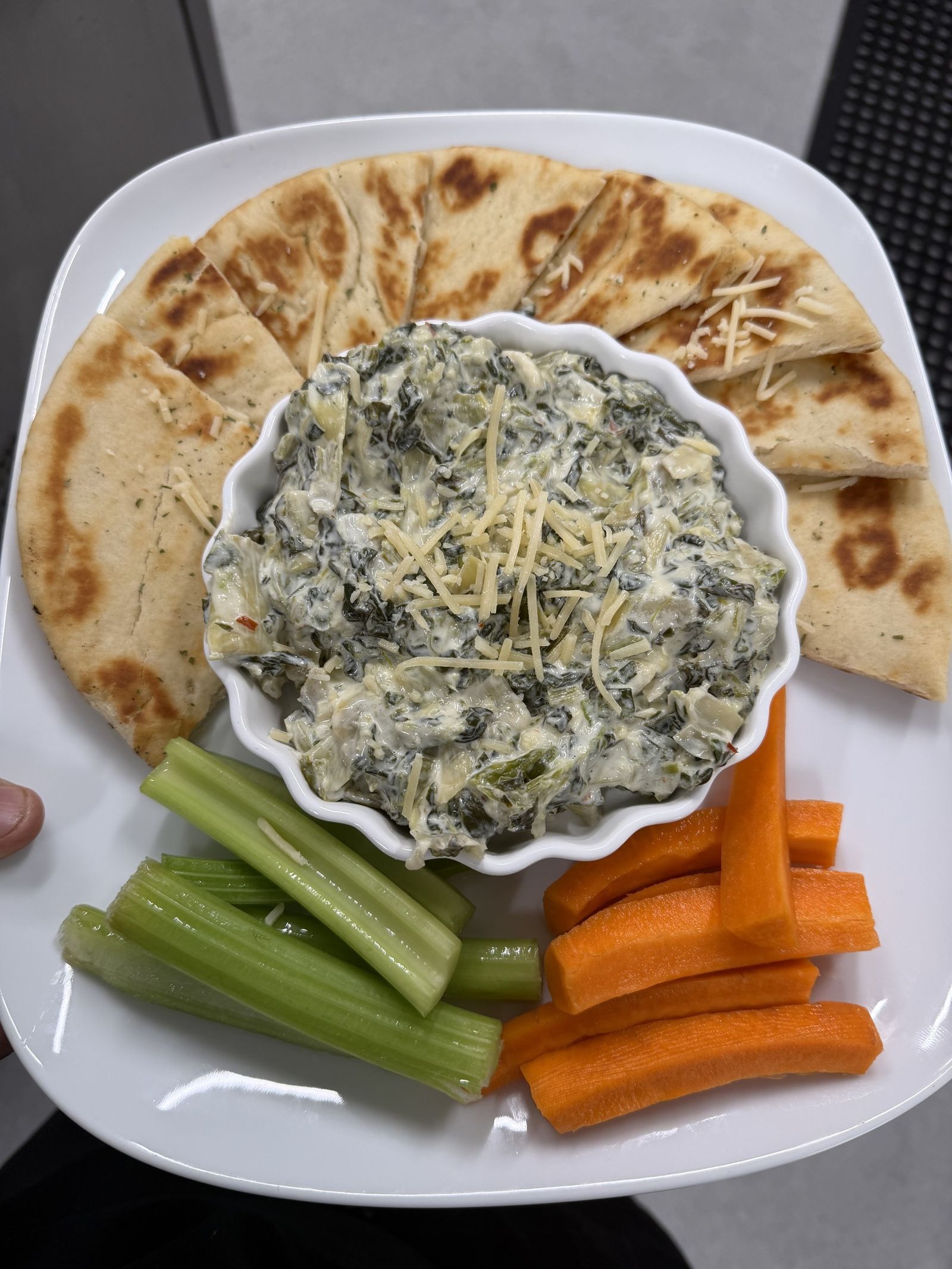 Spinach and artichoke dip with pita, celery and carrots